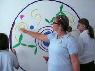 Nias pintando un mural enla pared
