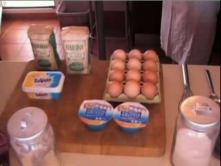 Alimentos sobre mesa (huevos, leche, matequilla)