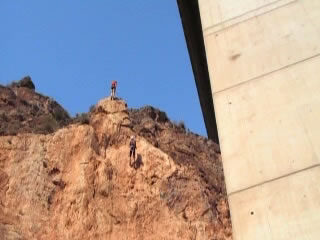 Dos jvenes escalando la pared vertical de una montaa