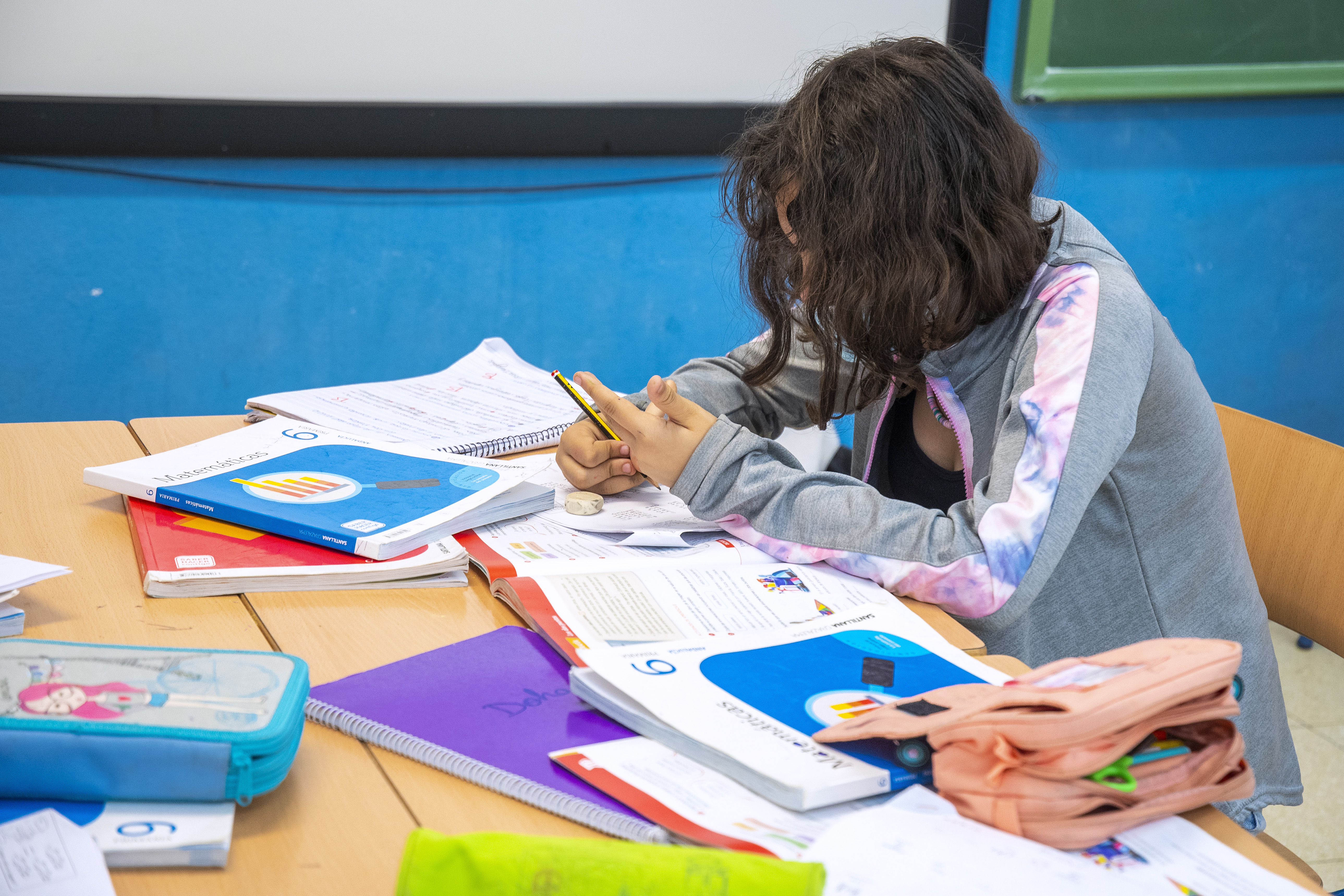 Estudiante en el aula con los libros de texto