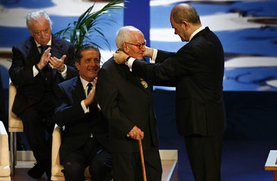 El sacerdote Francisco Girón recibe la Medalla de Andalucía de manos del presidente de la Junta, Manuel Chaves, con el aplauso de Federico Mayor Zaragoza y Tico Medina.