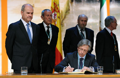 El médico Guillermo Antiñolo, en el momento de la firma en el Libro de Honor de la Junta de Andalucía, ante la mirada del presidente, Manuel Chaves.