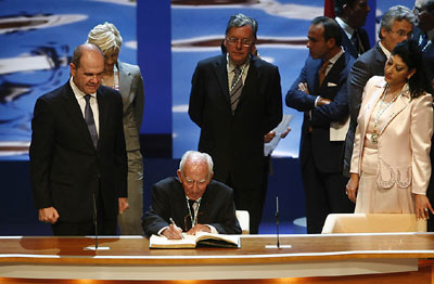 El sacerdote Francisco Girón firma en el Libro de Honor de la Junta de Andalucía, ante la mirada del presidente de la Junta.