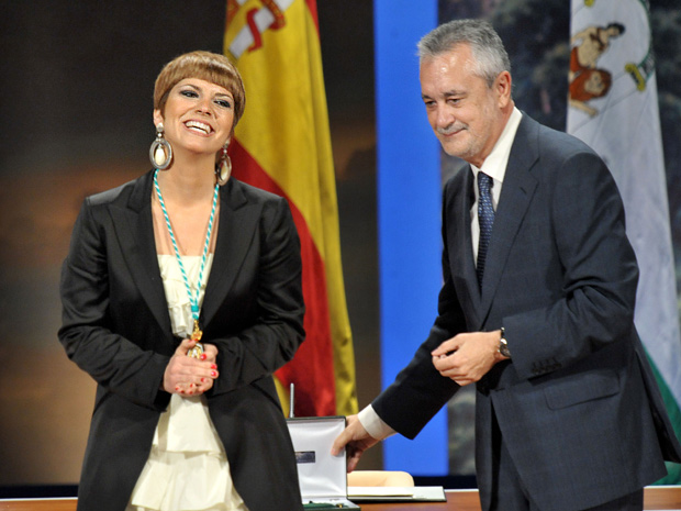 El presidente de la Junta, José Antonio Griñán, procede a la entrega de la Medalla de Andalucía a la cantante Pasión Vega, que saluda al público del Teatro de la Maestranza.