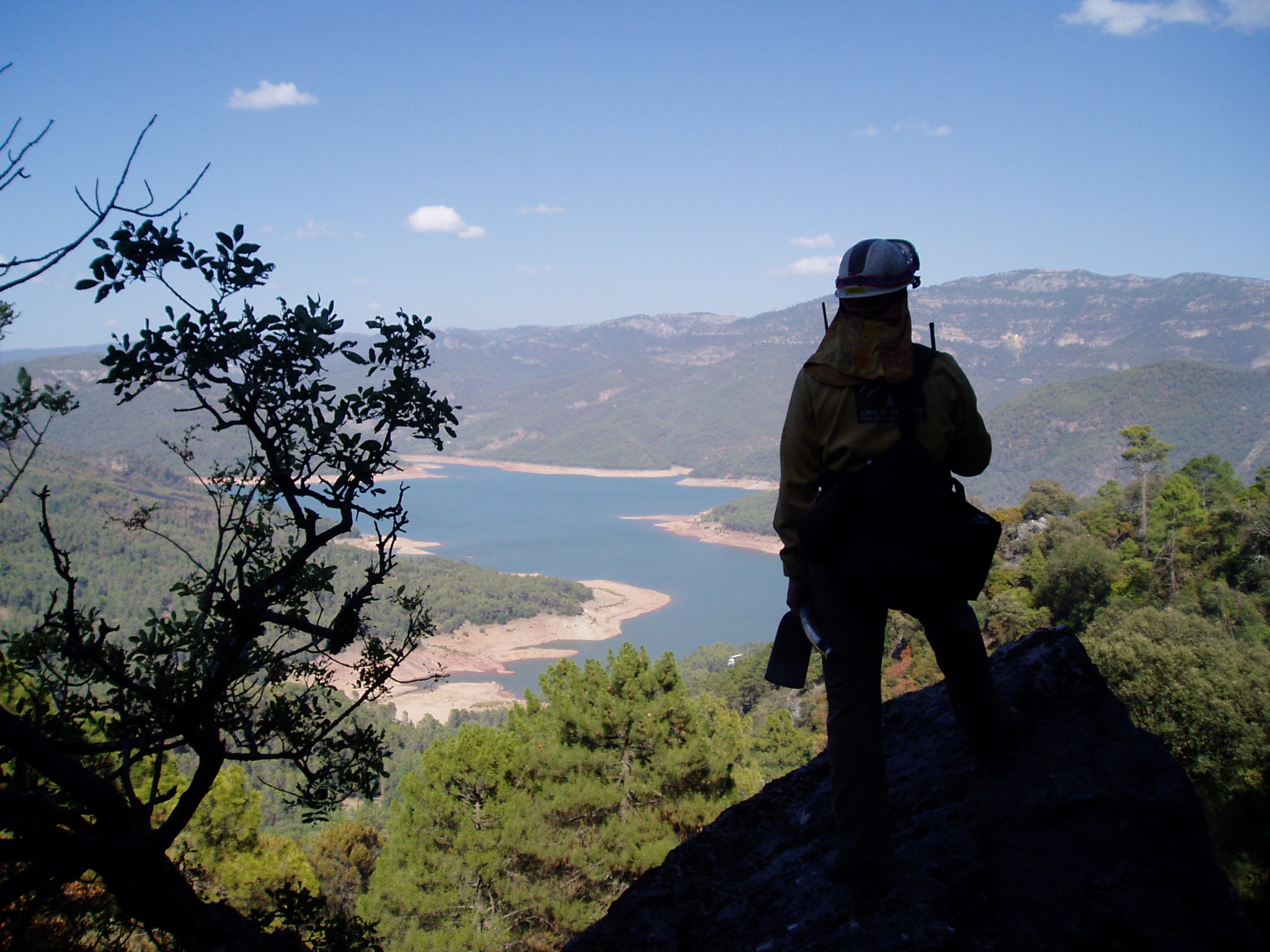 Ampliar imagen: operario del Plan INFOCA observando el monte desde la zona alta de la sierra