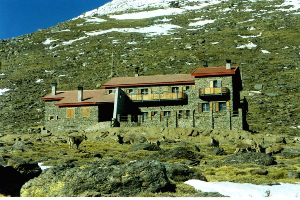 Ampliar imagen: refugio de Poquéira, de dos plantas con paredes de piedra del lugar, contrapuertas de madera y techos a dos aguas