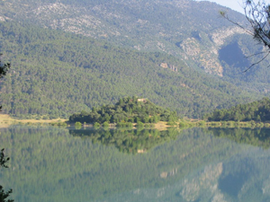 Paisaje con un lago en primer plano y un monte al fondo