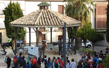 Grupo de personas recibiendo una charla en una plaza pública