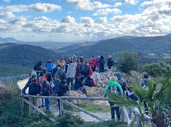 Grupo de personas en un mirador con la sierra de fondo