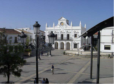 Plaza de una localidad con el ayuntamiento de fondo