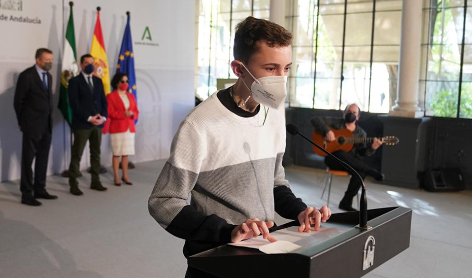 Un joven lee el Himno de Andalucía en Braille.