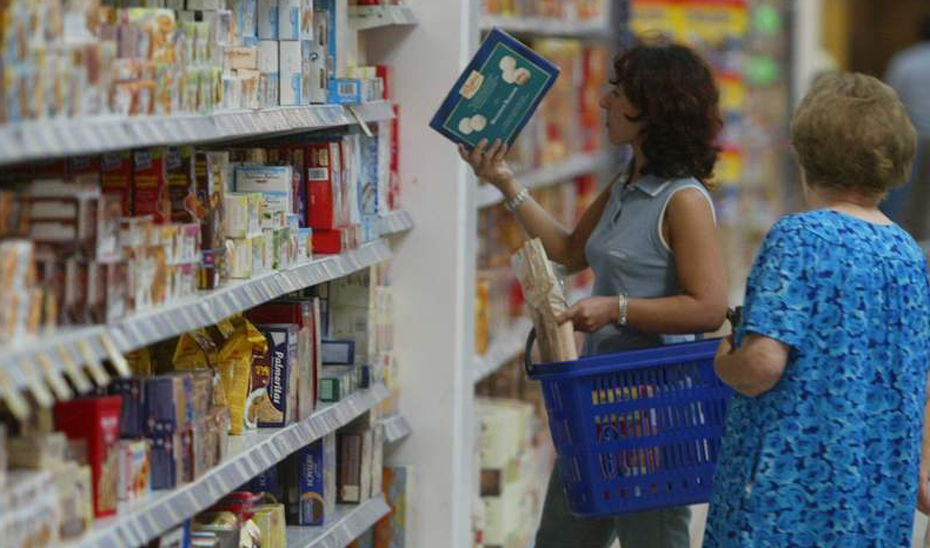 Una mujer comprueba la información en el envase de un producto en un supermercado.
