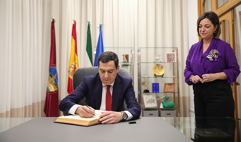 El presidente de la Junta, Juanma Moreno, firma en el libro de honor del Ayuntamiento de Córdoba, en presencia de la alcaldesa, Isabel Ambrosio.