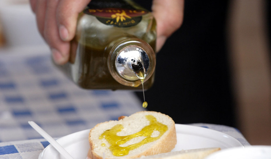 Cliente de un negocio hostelero sirviéndose aceite en pan.