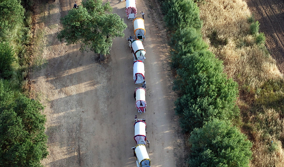 Vista aérea de una fila de carretas de romeros andaluces durante una peregrinación.