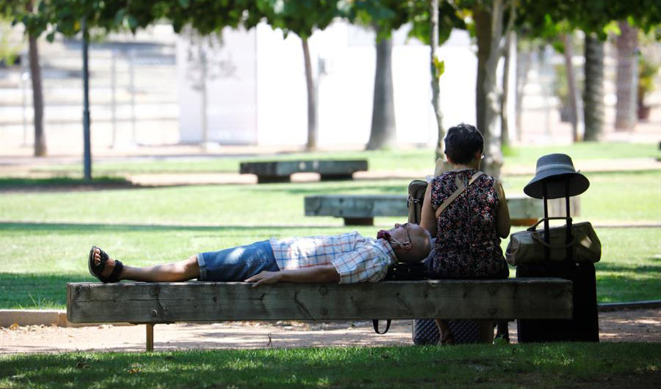 Un hombre descansa en un banco a la sombra (EFE).