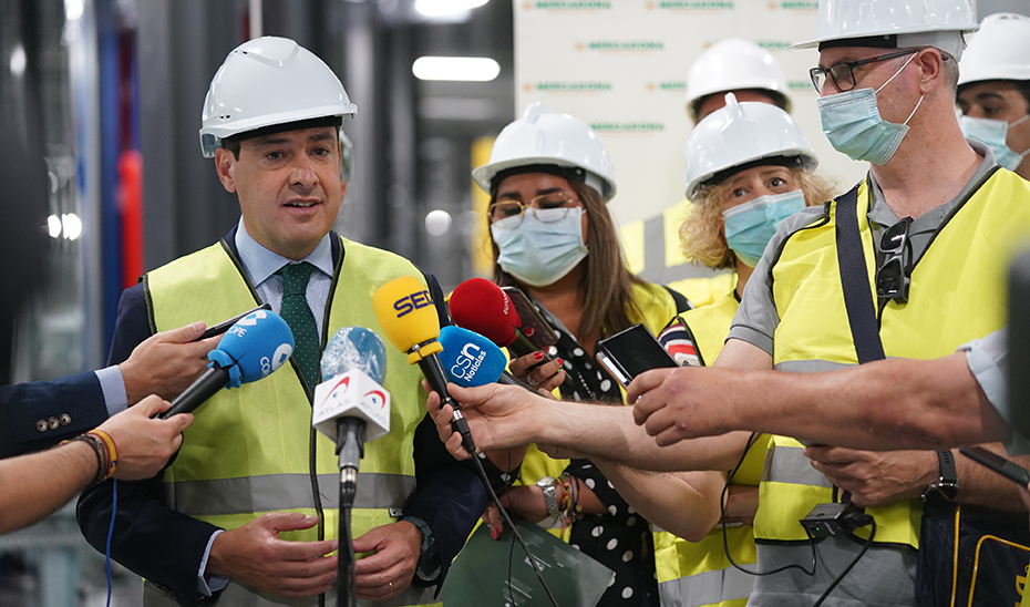 El presidente Juanma Moreno atiende a los medios durante su visita a la planta de Mercadona.