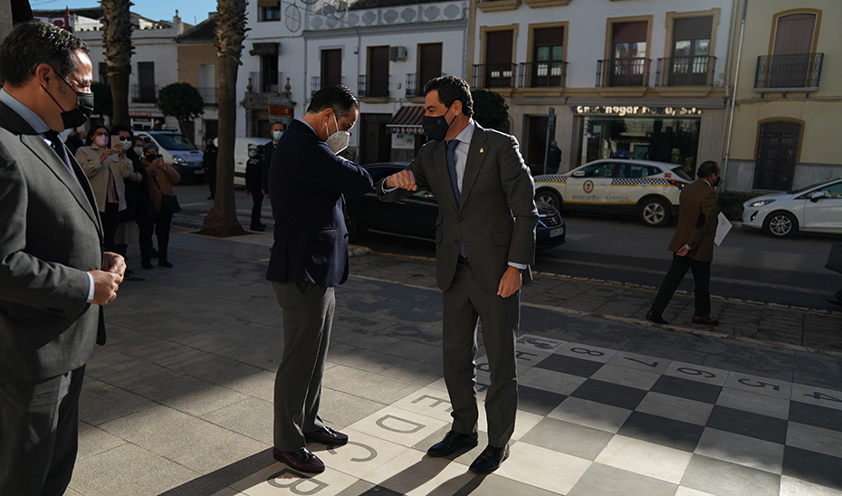 Juanma Moreno saluda al alcalde de La Roda de Andalucía, Juan Jiménez, a su llegada al Ayuntamiento.
