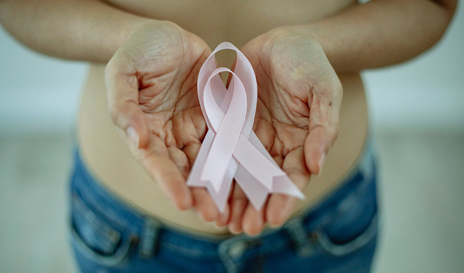 Una mujer porta lazos de color rosa para la concienciación sobre el cáncer de mama.