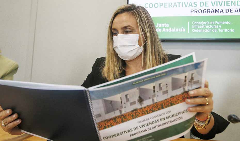 La consejera de Fomento, Marifrán Carazo, revisa un documento con el programa de autoconstrucción de viviendas.