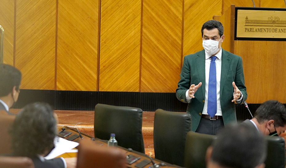 Juanma Moreno responde a las preguntas de la oposición desde su escaño en el Parlamento.