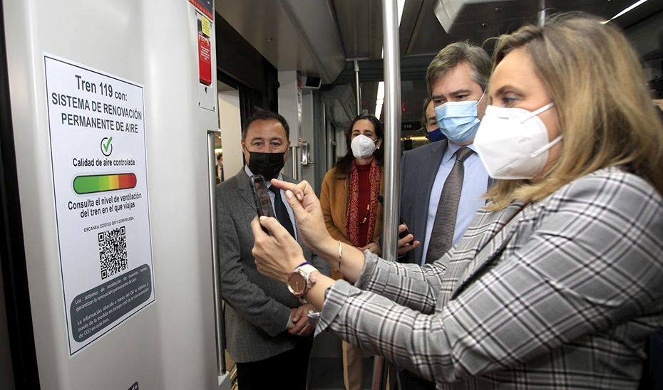 La consejera lee con su móvil el código QR en uno de los vagones del metro de Sevilla.