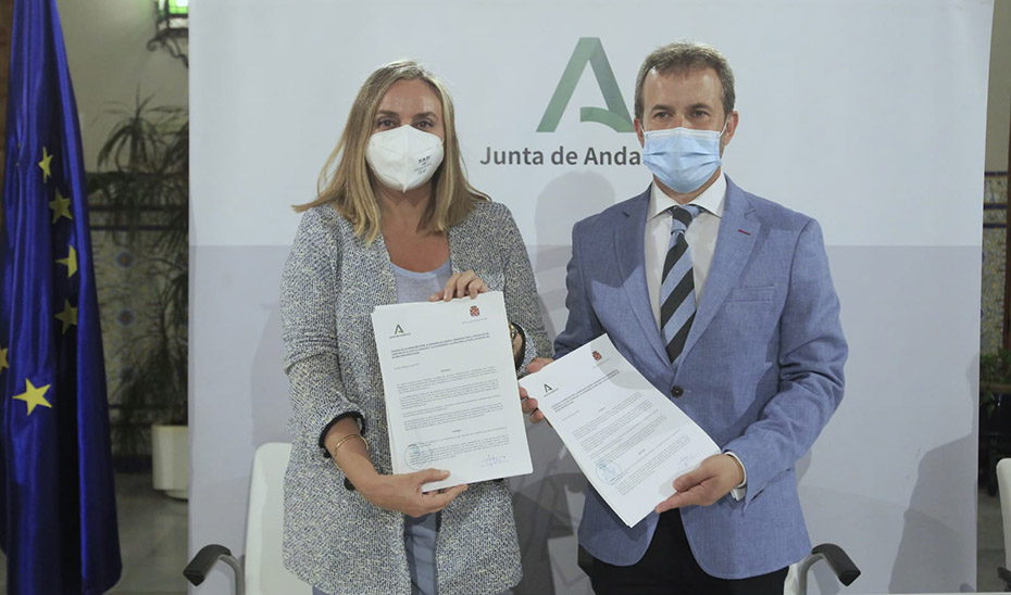 La consejera de Fomento, Marifrán Carazo, y el alcalde de Jaén, Julio Millán, muestran el convenio del tranvía recién firmado.