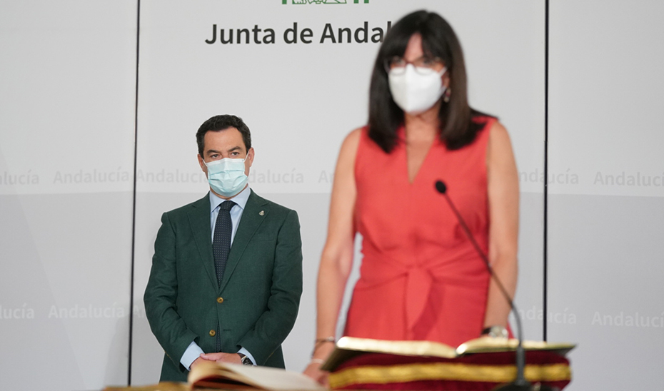 El presidente observa a Mª Antonia Peña en el momento de tomar posesión de su cargo.