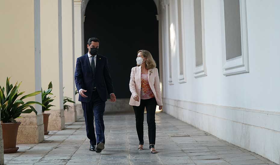 Juanma Moreno y Nadia Calviño recorren uno de los pasillos de San Telmo tras la reunión.