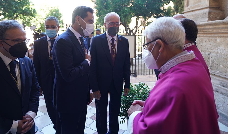 El presidente de la Junta y el alcalde de Málaga saludan al obispo a su llegada a la Catedral.