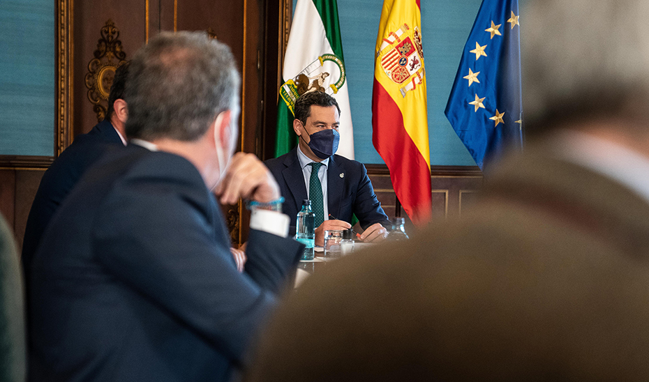 El presidente de la Junta, Juanma Moreno, escuchando a los agentes sociales durante la reunión.