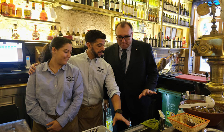 Arturo Bernal conversa con dos camareros en un restaurante de Sevilla.