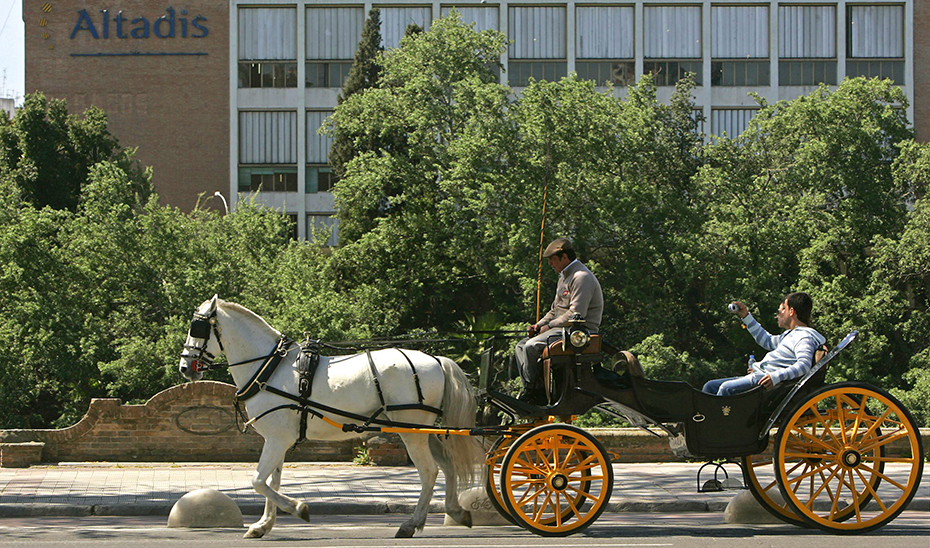 Un coche de caballos pasa por delante de la antigua fábrica de Altadis en Sevilla. (Foto: EFE)