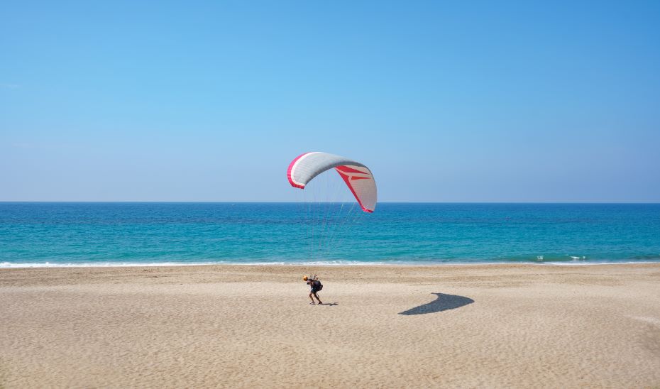 Parapentista en una playa.