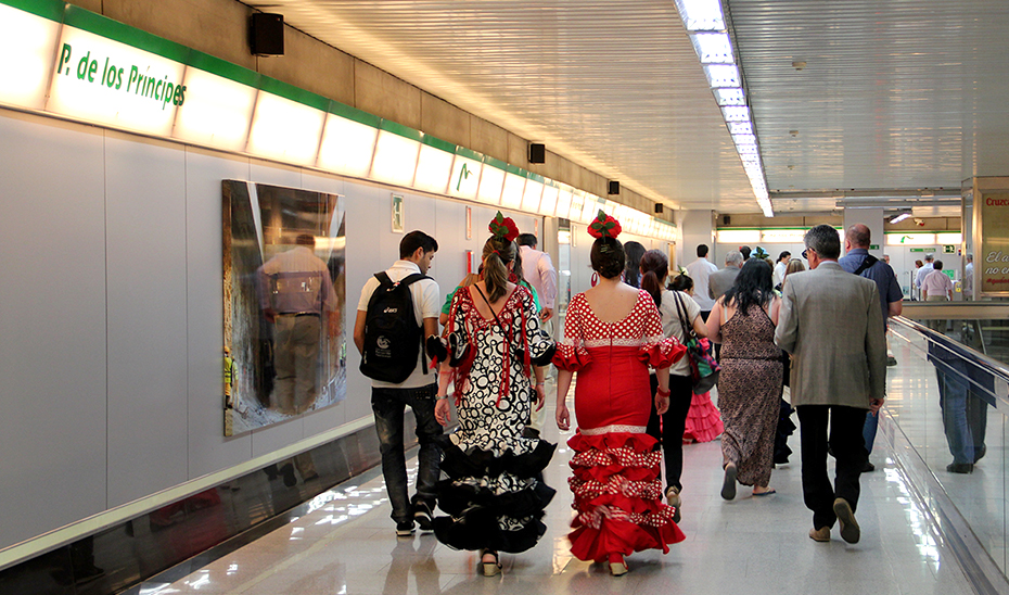 Varias mujeres vestidas de flamenca en la estación del Parque de los Príncipes del metro de Sevilla.