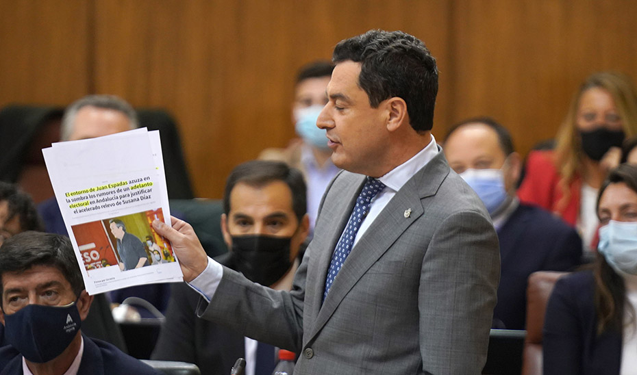 Juanma Moreno muestra un recorte de prensa durante la sesión de control en el Parlamento de Andalucía.