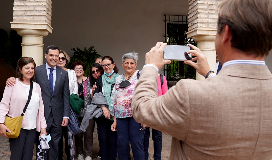 El presidente andaluz se fotografía con algunos ciudadanos durante su visita a los Patios de Córdoba.
