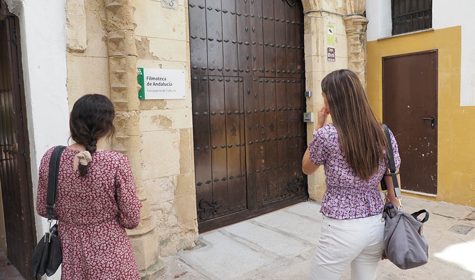 Dos jóvenes, ante la entrada de la sede de la Filmoteca de Andalucía, en el antiguo Hospital de San Sebastián de Córdoba.