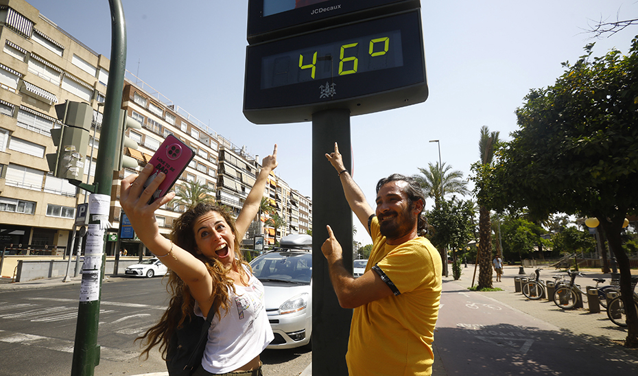Dos turistas se fotografían junto a un termómetro que marcaba esta semana 46º en Córdoba. (Foto: EFE)