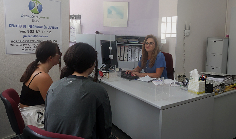 Dos jóvenes reciben atención en el centro de información juvenil de Ronda, en la provincia de Málaga.