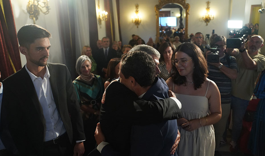 El presidente andaluz saluda durante el acto al viudo y los hijos de Belén Vílchez.