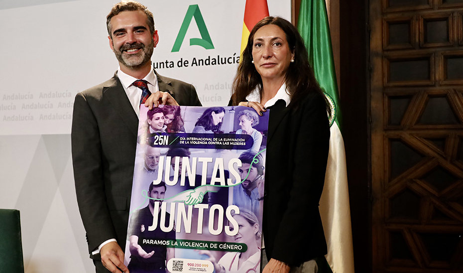 Los consejeros Ramón Fernández-Pacheco y Loles López posan con el cartel de la campaña de la Junta con motivo del 25 de Noviembre.