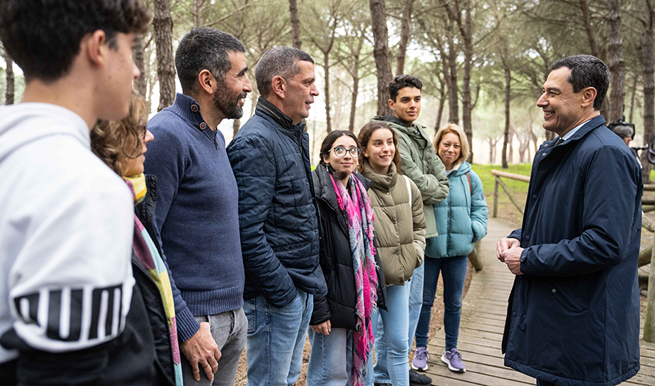 Juanma Moreno, junto a unos visitantes del Parque de Doñana, en el transcurso de su mensaje navideño de 2023.