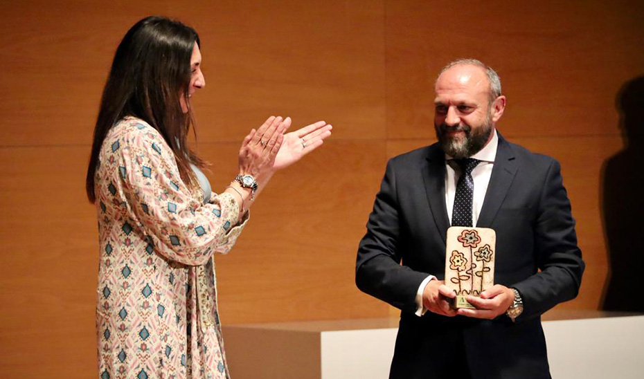 La consejera de Inclusión Social, Loles López, entrega el galardón al presidente de Proyecto Hombre Granada, Manuel Mingorance.