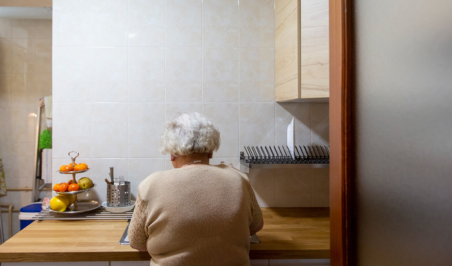 Una mujer mayor en el interior de la cocina de su domicilio.