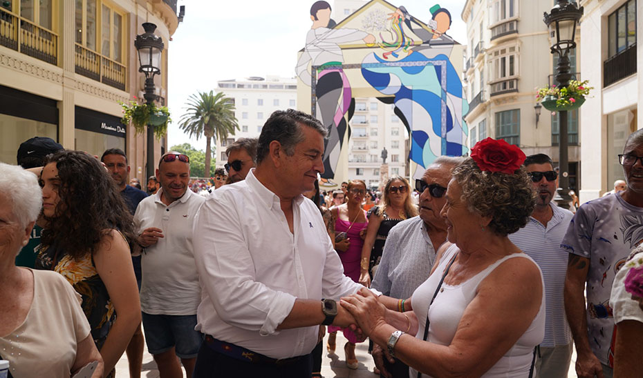 El consejero de la Presidencia, Antonio Sanz, conversa con una asistente a la Feria del Centro en Málaga.