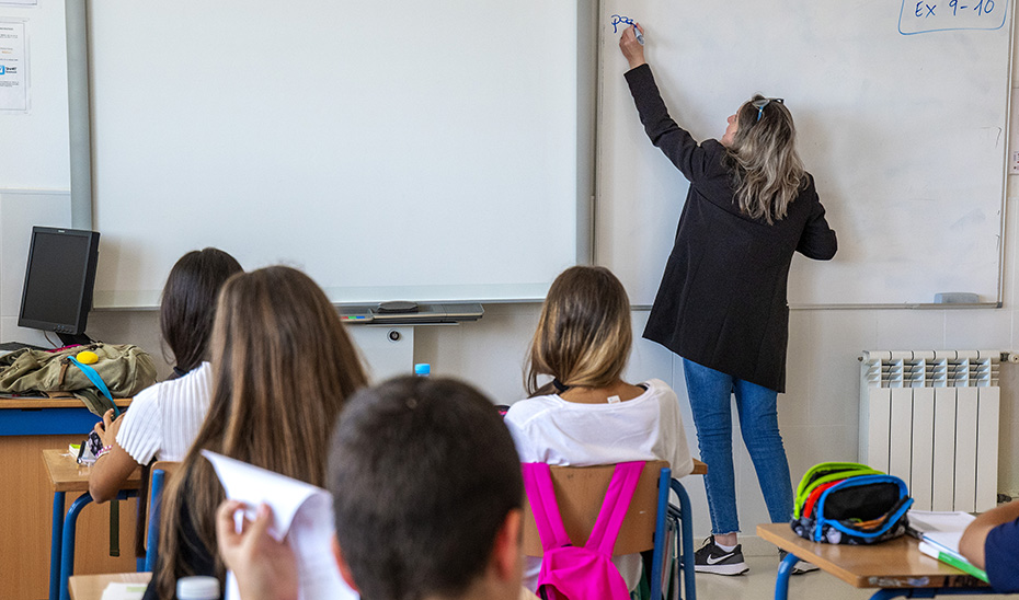 Maestra impartiendo clase en un aula.