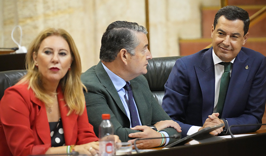 Moreno, junto a los consejeros Antonio Sanz y Carolina España, en su escaño del salón del Plenos de la Cámara autonómica.