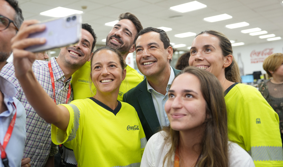 Juanma Moreno se hace un selfi junto a un grupo de trabajadores de la empresa.