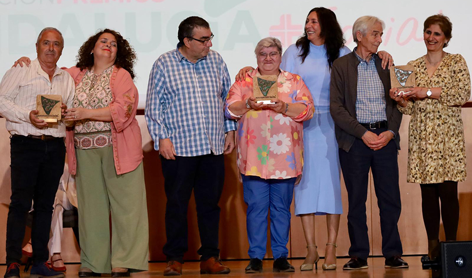 La consejera de Inclusión Social, Loles López, junto a las tres familias de acogida que han sido galardonadas en la modalidad de atención a la infancia y adolescencia.